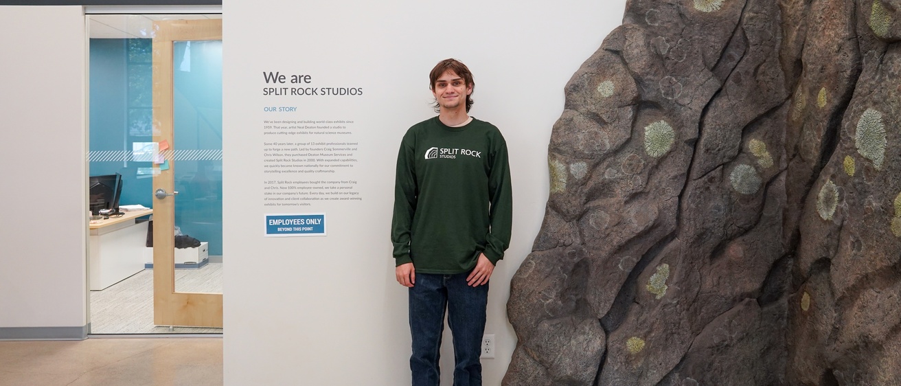 Sam Akerman standing in front of Split Rock Studios sign